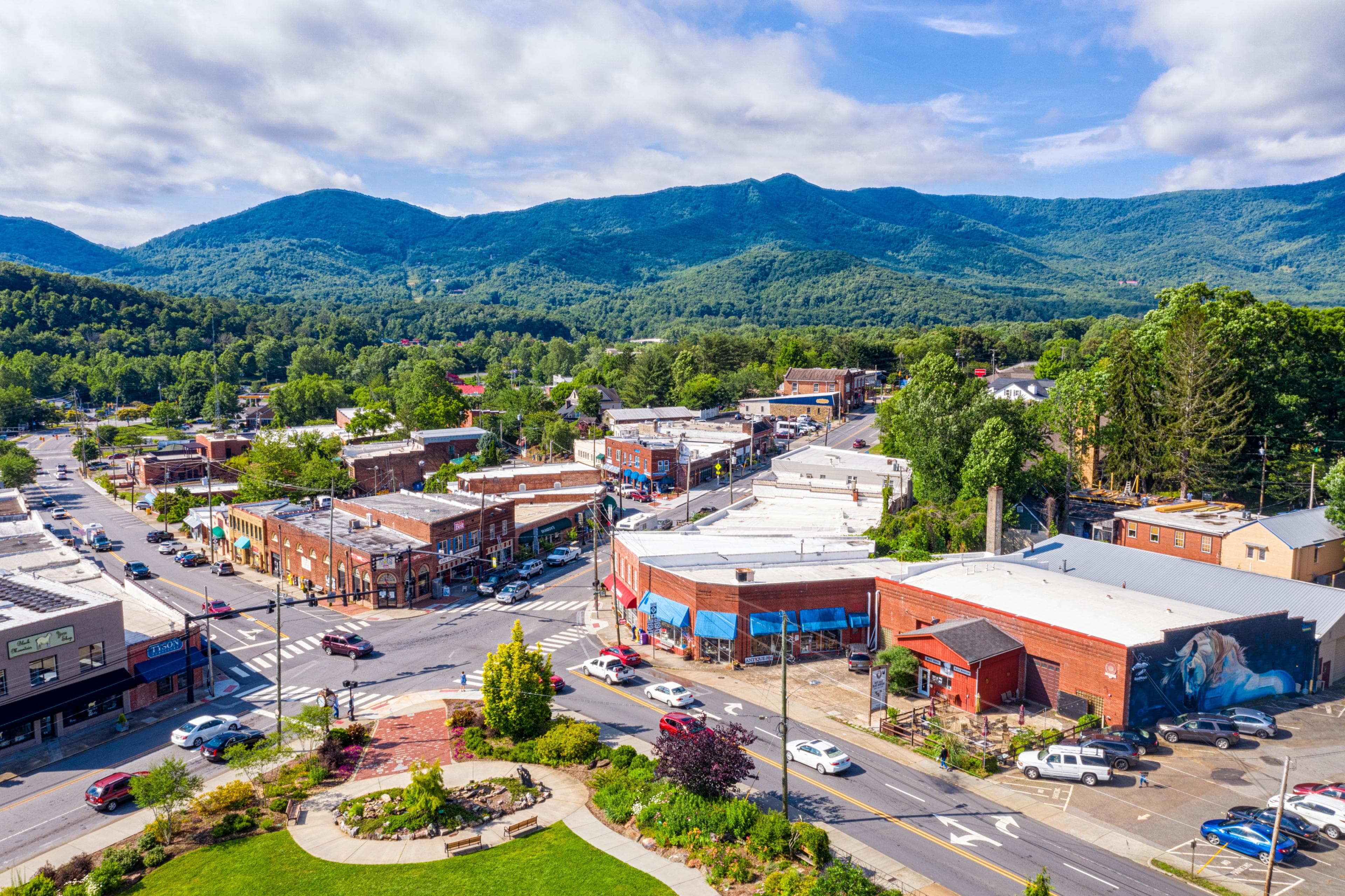 an aerial view of a Black Mountain neighborhood with mountains in the background an aerial view of a Black Mountain neighborhood with mountains in the background
