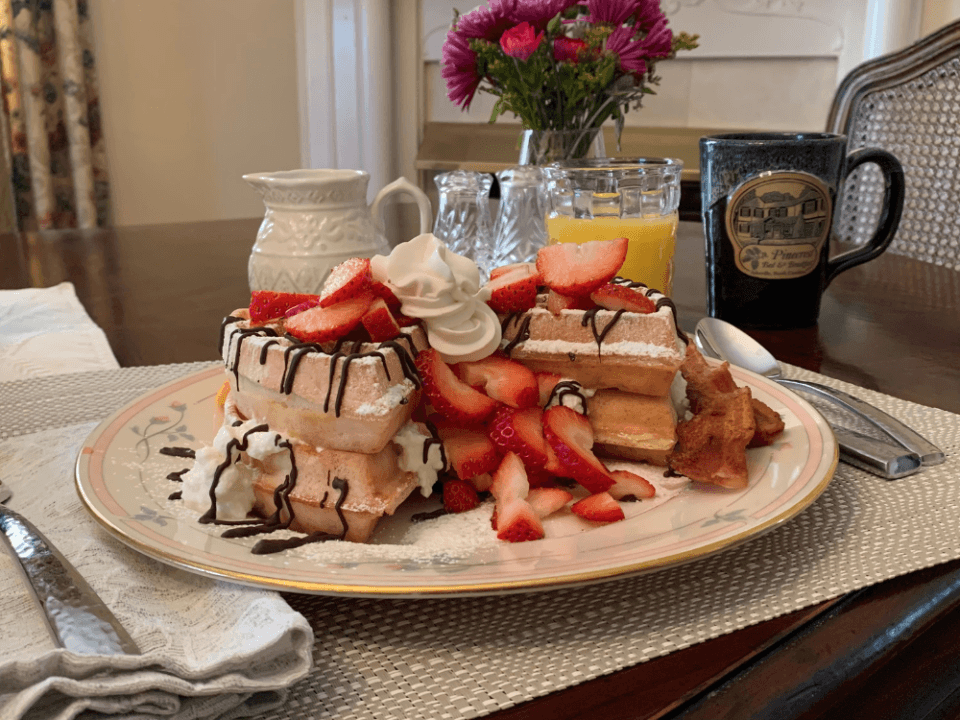 Stacked waffles with fresh strawberries, chocolate drizzle and whipped cream served on fine china at Pinecrest Bed and Breakfast in Asheville NC Stacked waffles with fresh strawberries, chocolate drizzle and whipped cream served on fine china at Pinecrest Bed and Breakfast in Asheville NC