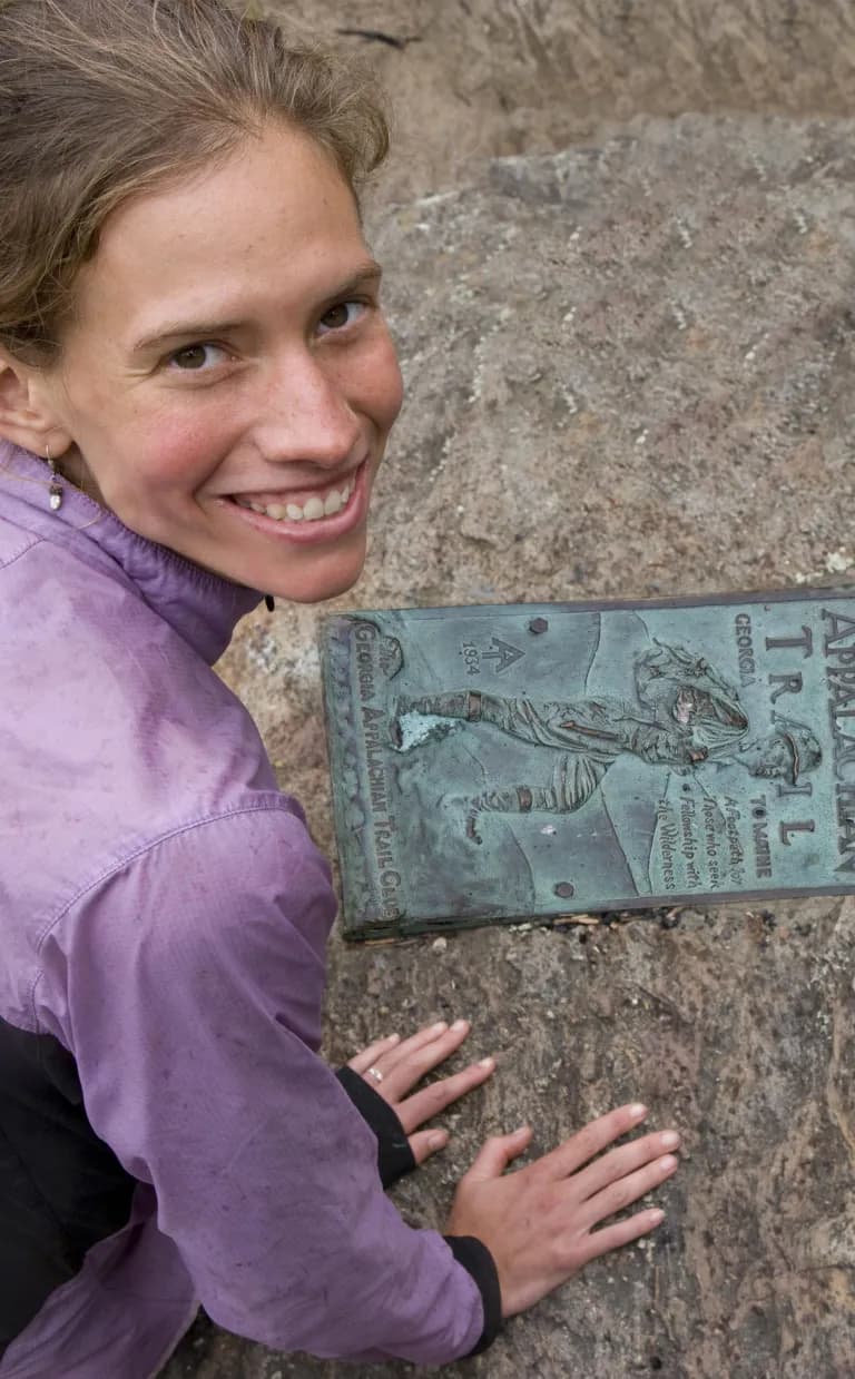 Hiking in Asheville, N.C. A hiker poses next to an Appalachian Trail plaque