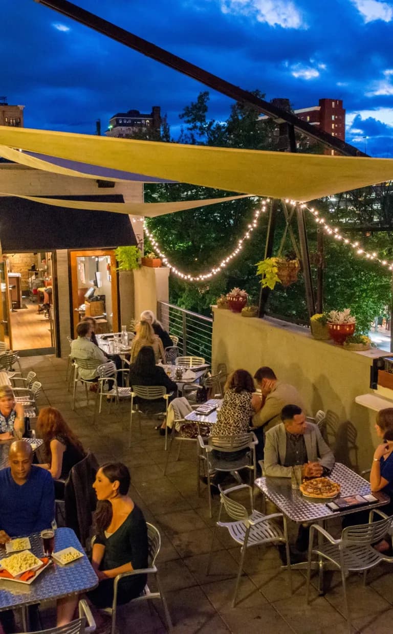 Late Night Things to Do in Asheville People sit at tables on an outdoor patio in Asheville