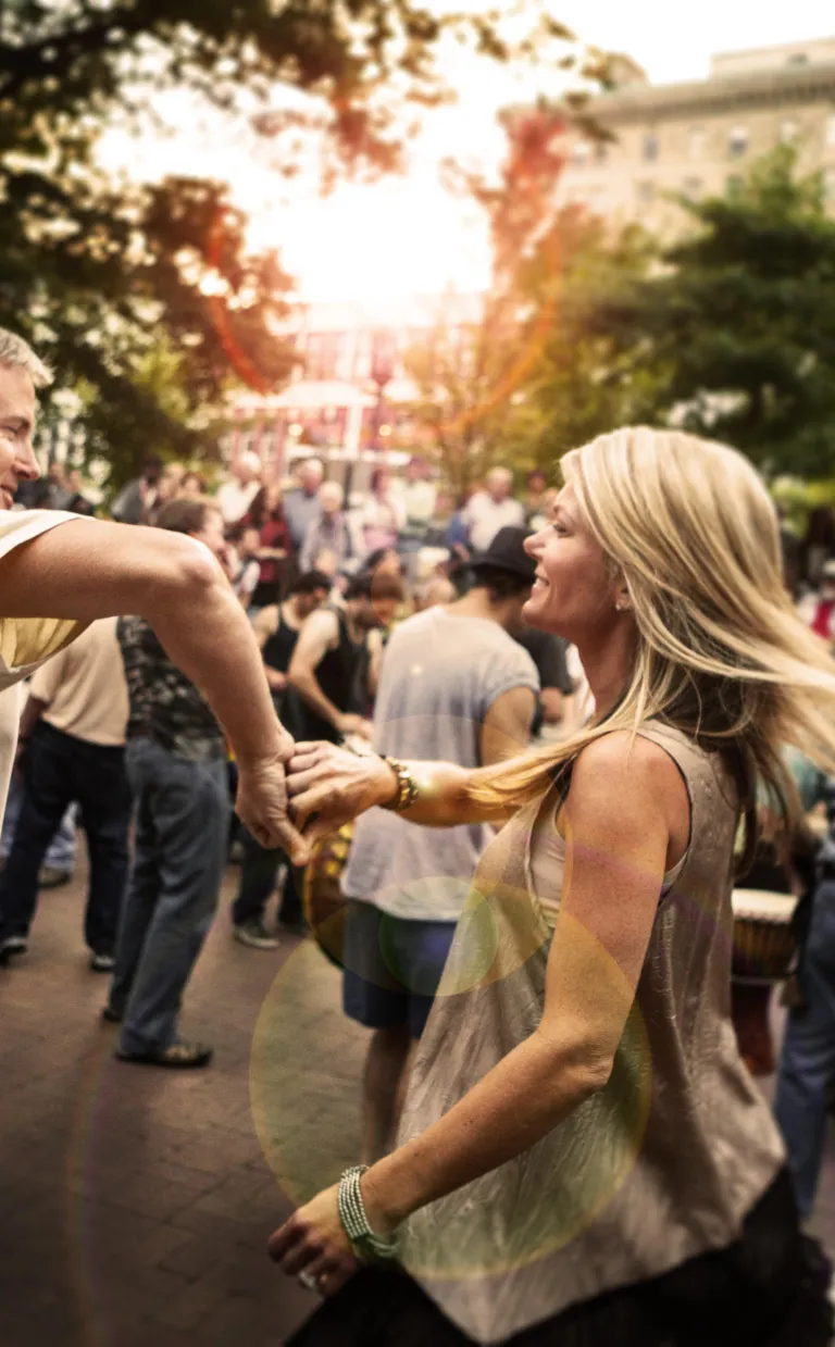 Where to Dance in Asheville two people smile as they dance in a square in Asheville