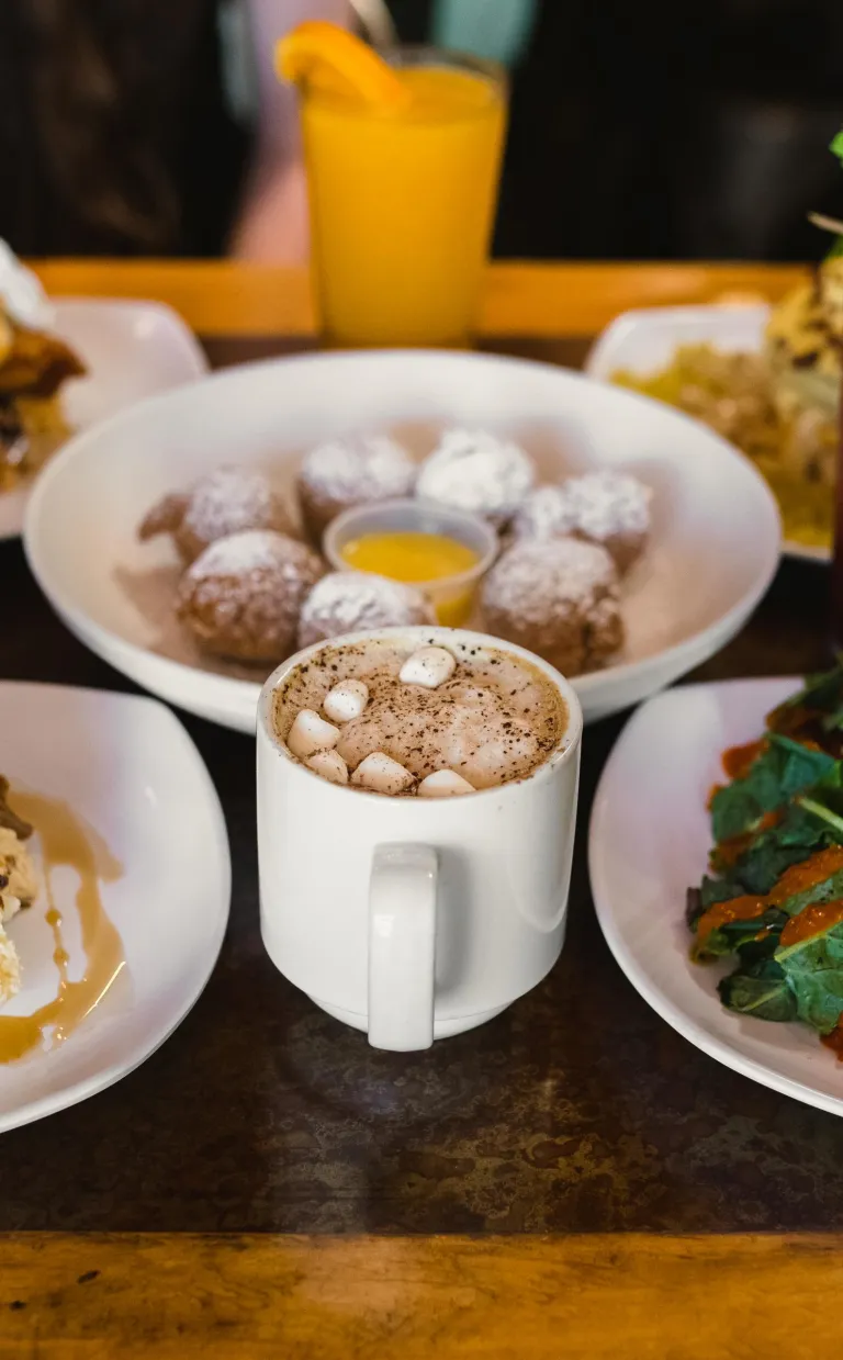 Where to Eat Brunch in Asheville An omelette, powdered donuts, coffee and other brunch items are beautifully displayed on a table at a restaurant in Asheville
